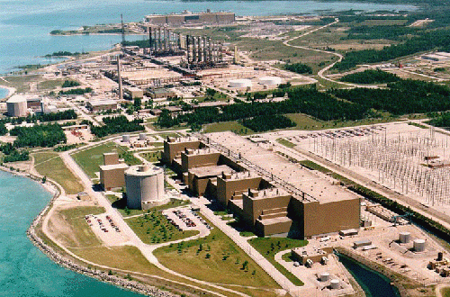 Les centrales nucléaires de Bruce 1 à 4 (en arrière-plan) et Bruce 5 à 8 (au premier plan) exploitées par Bruce Power avec, entre les deux, une usine de fabrication d'eau lourde désaffectée, au Lac Huron, Ontario, Canada.
