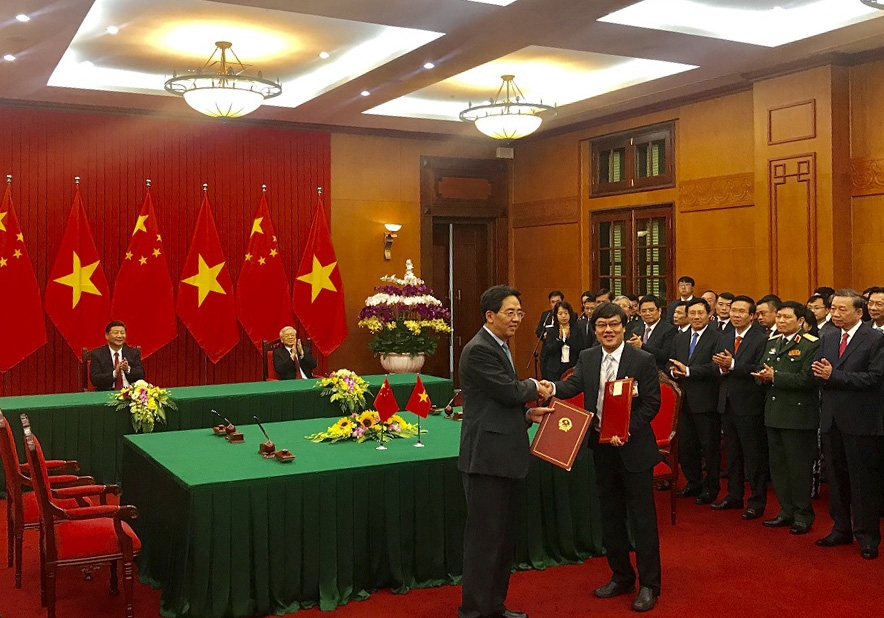 Der chinesische Botschafter in Vietnam, Hong Xiaoyong (links), und der Generalsekretär der Varans, Nguyen Tuan Khai, überreichen sich die unterzeichneten Urkunden.