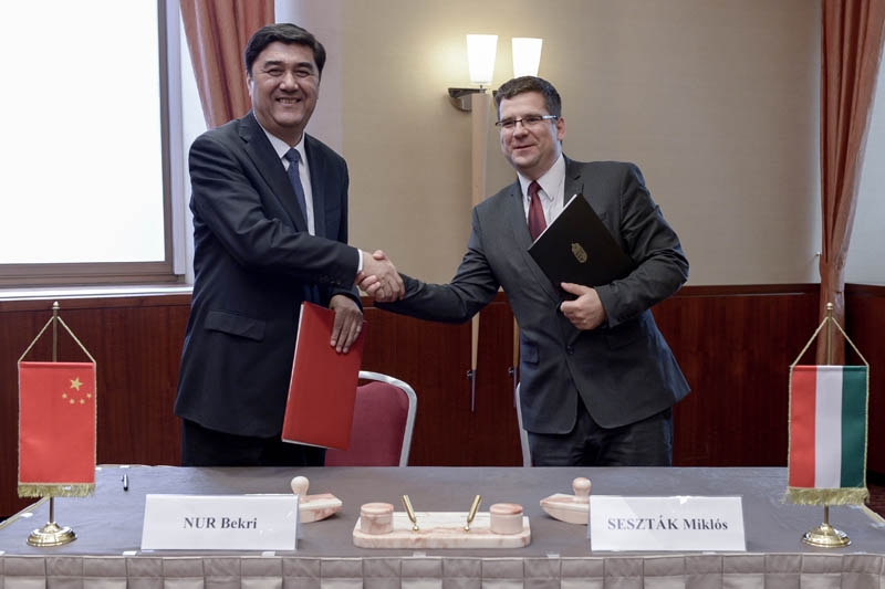 Nur Bekri, président de l’Administration nationale chinoise de l’énergie, et Miklos Sesztak, ministre hongrois du Développement national, échangent la déclaration d’intention signée.