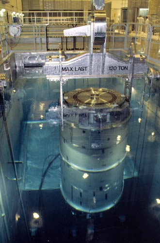 Ein Transportbehälter mit ausgedientem Kernbrennstoff wird in das Verladebecken des zentralen Zwischenlagers «Clab» in Oskarshamn abgesenkt. Das «Clab» befindet sich 40 m unter der Erdoberfläche und ist ein Nasslager.