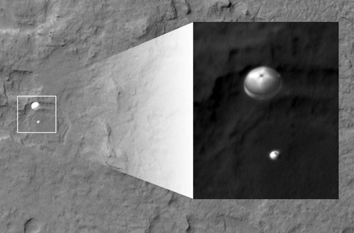 Seltene Ansicht: Der Nasa-Satellit Mars Reconnaissance Orbiter fliegt über das Landegebiet und schiesst ein Foto von Curiosity. Im Bild zu erkennen ist der Fallschirm mit der darunter hängenden Sonde.