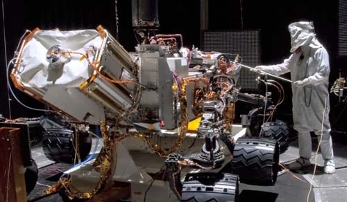 Der Rover wird vor dem Start auf Herz und Nieren getestet. Das Bild zeigt das Fahrzeug bei einem der «shake and bake»-Tests. Hier werden verschiedene mechanische (shake) und thermische (bake) Einflüsse während der Mission simuliert. In der linken Bildhälfte zu sehen ist der MMRTG – die «nukleare Batterie» des Rover.