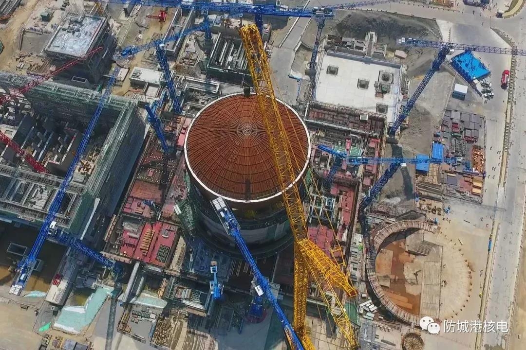 Die rund 14 m hohe und 45 m breite Reaktorkuppel von Fangchenggang-3 wird auf eine Höhe von über 60 m gehoben, um danach auf das Reaktorgebäude gesetzt zu werden.