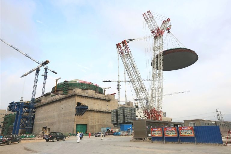 Die äussere Containmentkuppel von Fuqing-6 wird auf das Reaktorgebäude positioniert.