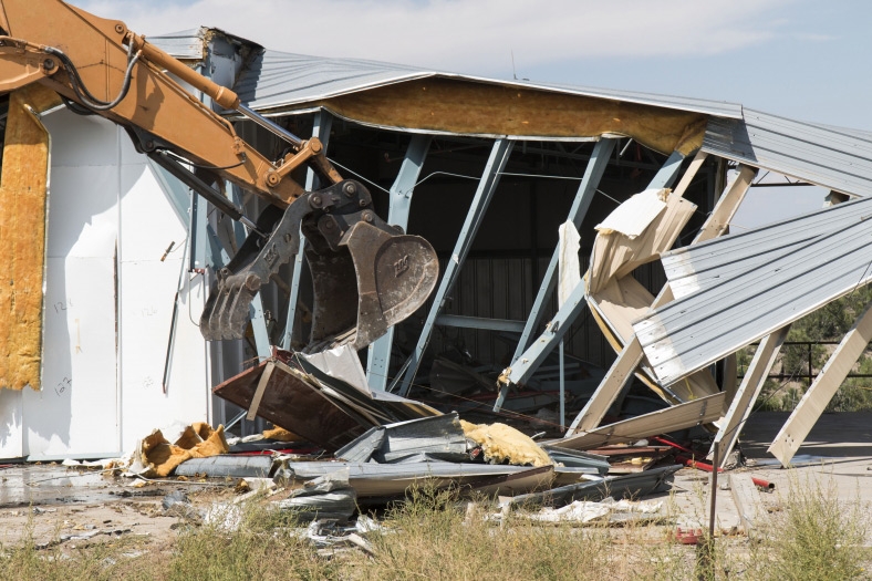 Des travailleurs démolissent une ancienne halle de stockage sur le site historique de Los Alamos.