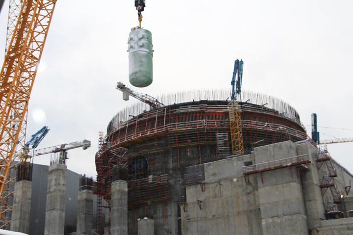 Das Reaktordruckgefäss wird mit einem Kran ins Reaktorgebäude von Leningrad-II-2 gehoben.