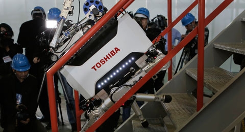 Le robot à quatre pattes de Toshiba en train de monter un escalier. L’appareil est destiné à des missions d’exploration dans des secteurs de la centrale de Fukushima-Daiichi présentant une trop grande contamination pour l’homme.