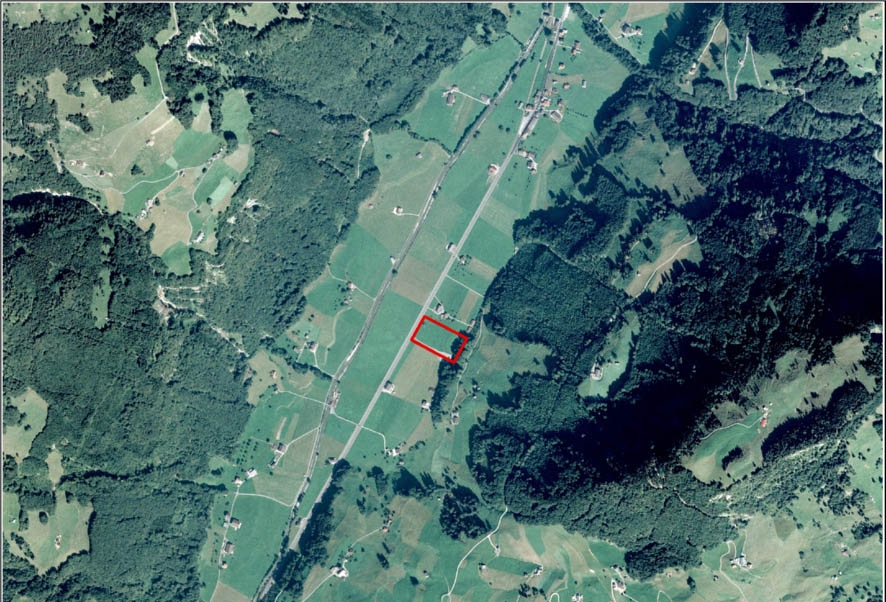Orthophoto avec les dimensions et la situation de la zone d’implantation WLB-1 DFMR pour la disposition de l’installation de surface d’un dépôt en couches géologiques profondes de déchets de faible et moyenne activité. Elle se situe dans la commune de Wolfenschiessen, sur les flancs de la vallée de l’Engelberg, à proximité de la voie ferrée et de la route cantonale. Elle n’est visible d’aucune grande zone d’habitation.
