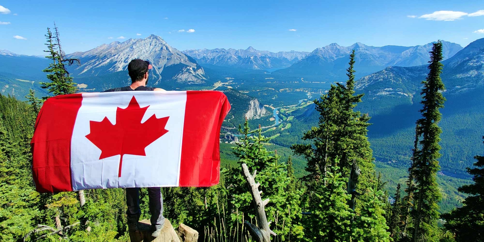Le drapeau canadien, en arrière plan des montagnes